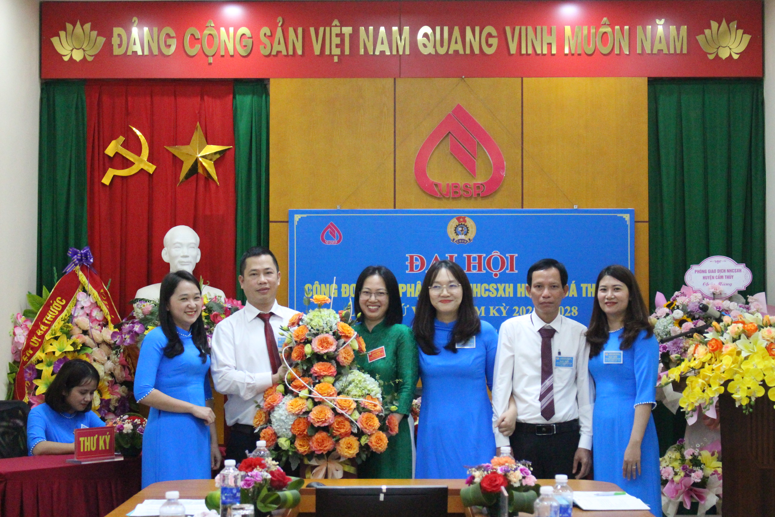 Đồng chí Hà Kiều Oanh, Ủy viên BCH Công đoàn cơ sở NHCSXH tỉnh và đồng chí Trịnh Anh Tuấn, Giám đốc NHCSXH huyện tặng hoa chúc mừng Ban chấp hành Công đoàn bộ phận Phòng giao dịch NHCSXH Bá Thước khóa VII, nhiệm kỳ 2023-2028