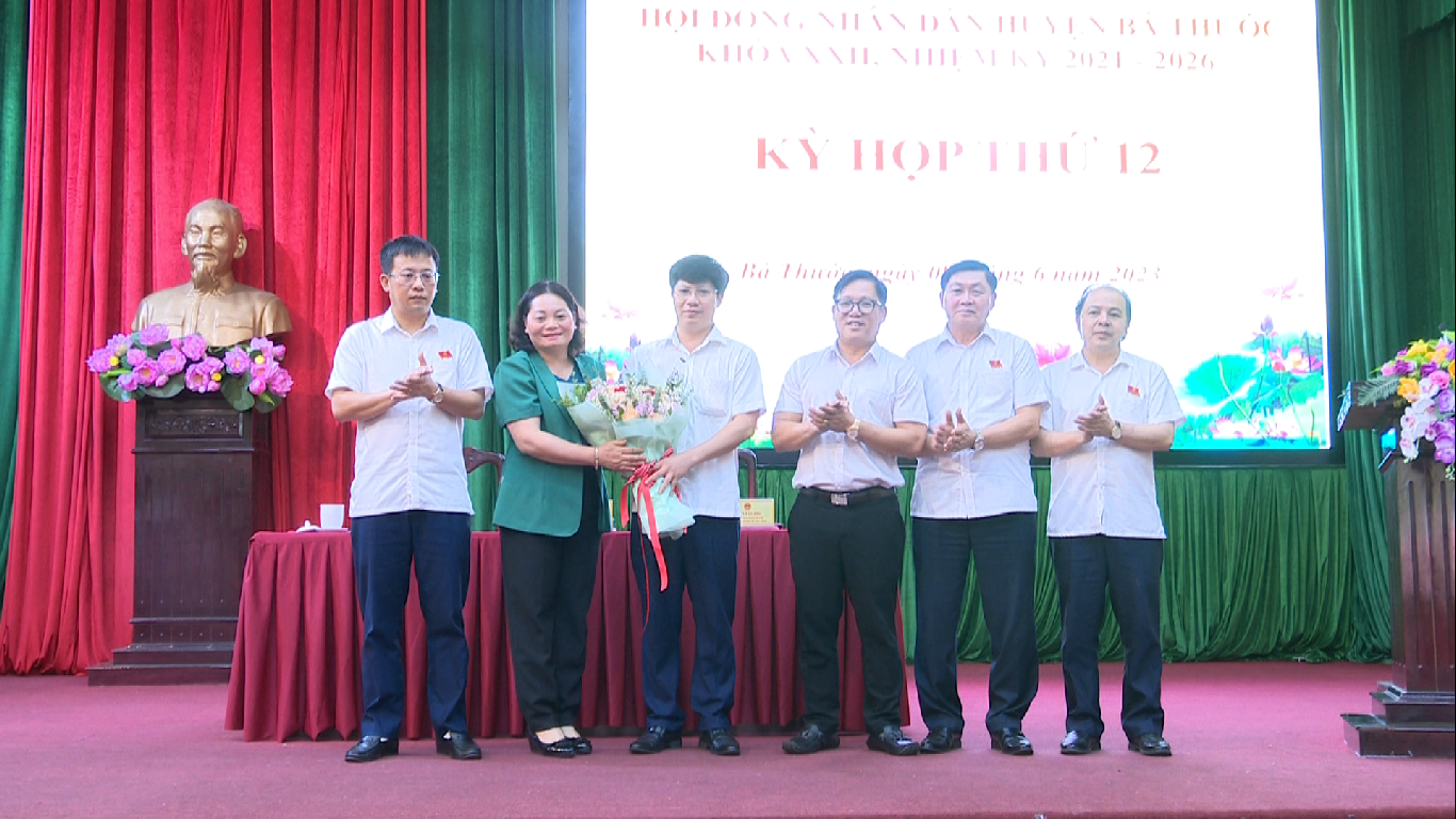 Đồng chí Phó Bí thư Thường trực Huyện uỷ, Chủ tịch HĐND huyện Bùi Thị Hoa; đồng chí Ngọ Đình Hải, Phó Bí thư Huyện uỷ, Chủ tịch UBND huyện cùng các đồng chí lãnh đạo huyện tặng hoa chúc mừng đồng chí Tống Minh Hoá