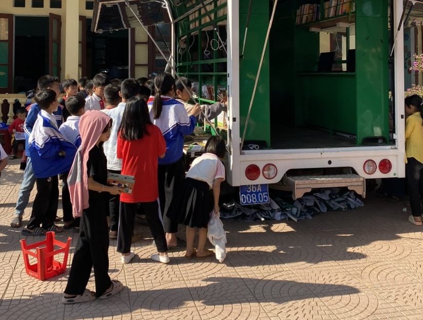 Các em học sinh Trường Tiểu học Lũng Niêm thăm quan khu trưng bày xe Thư viện lưu động đa phương tiện của Thư viện tỉnh.