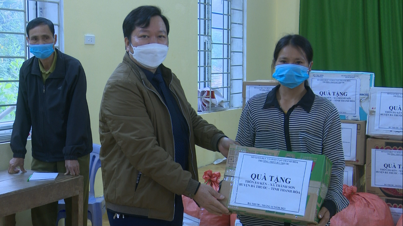 Đồng chí Trần Văn Thuấn, Phó hiệu trưởng, Chủ tịch Hội Chữ thập đỏ trường THPT Bá Thước trao quà cho hộ nghèo ở thôn Eo Kén, xã Thành Sơn