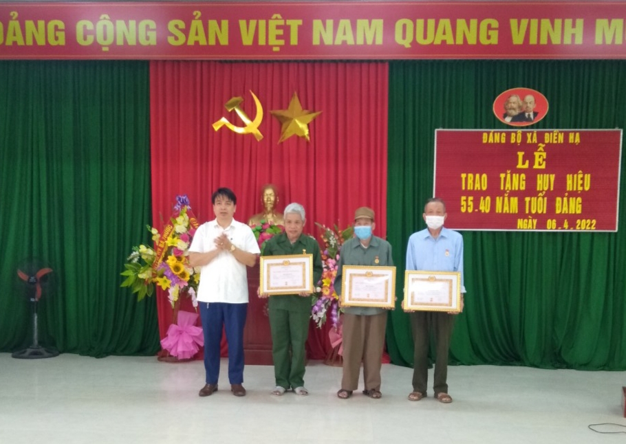Đồng chí Hà Tự Nhiên, Ủy viên Ban Chấp hành Đảng bộ huyện, Trưởng phòng Giáo dục & Đào tạo huyện trao Huy hiệu Đảng cho các đảng viên